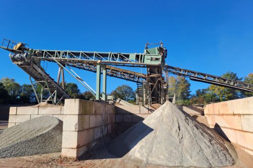 hills of recycled material in front of a conveyor belt