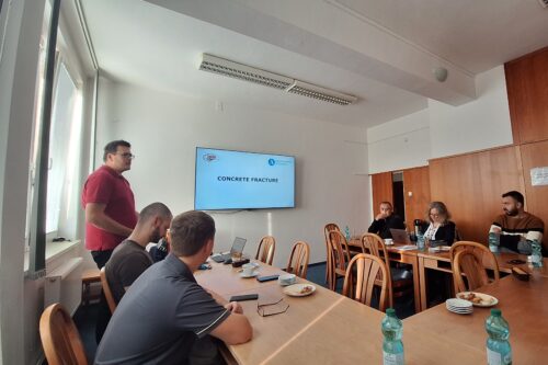 a monitor and several people in a conference room