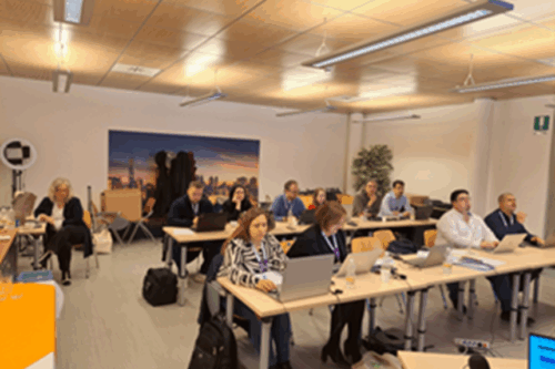 people sitting at desks in a room with notebooks