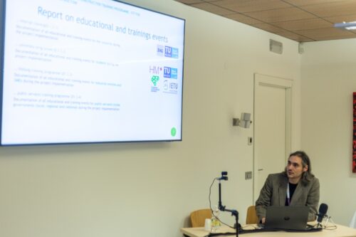 A man sitting looking at a projector screen