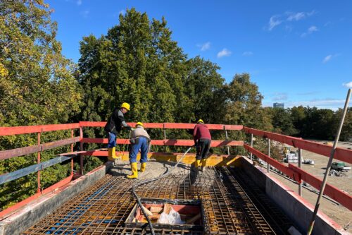 three persons pouring a concrete element
