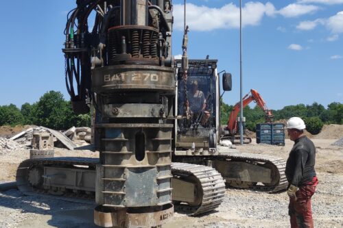 a man standing next to a drill