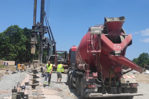 a mobile concrete mixer standing next to a drill