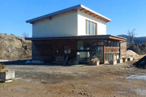 outside of a white house with wooden elements and big windows